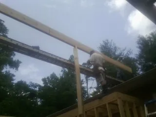 Carpenter setting a ridge beam over a new addition frame — Ice Dam Removal by Roofing Brothers in Wilmore