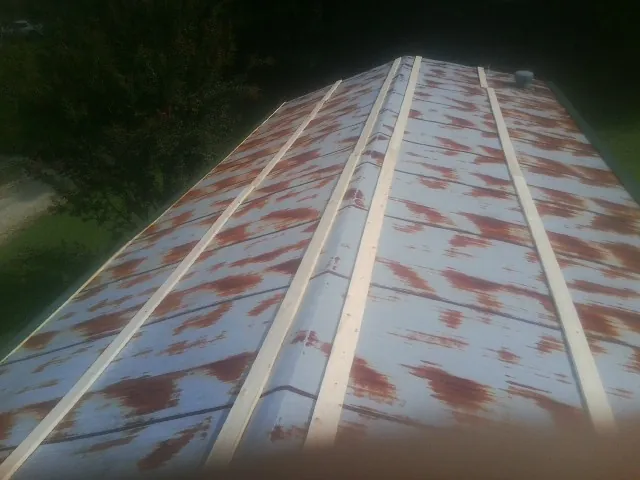 Rusted metal roof panels with new wood purlins before replacement — Storm Damage Roof Repair in Wilmore by Roofing Brothers