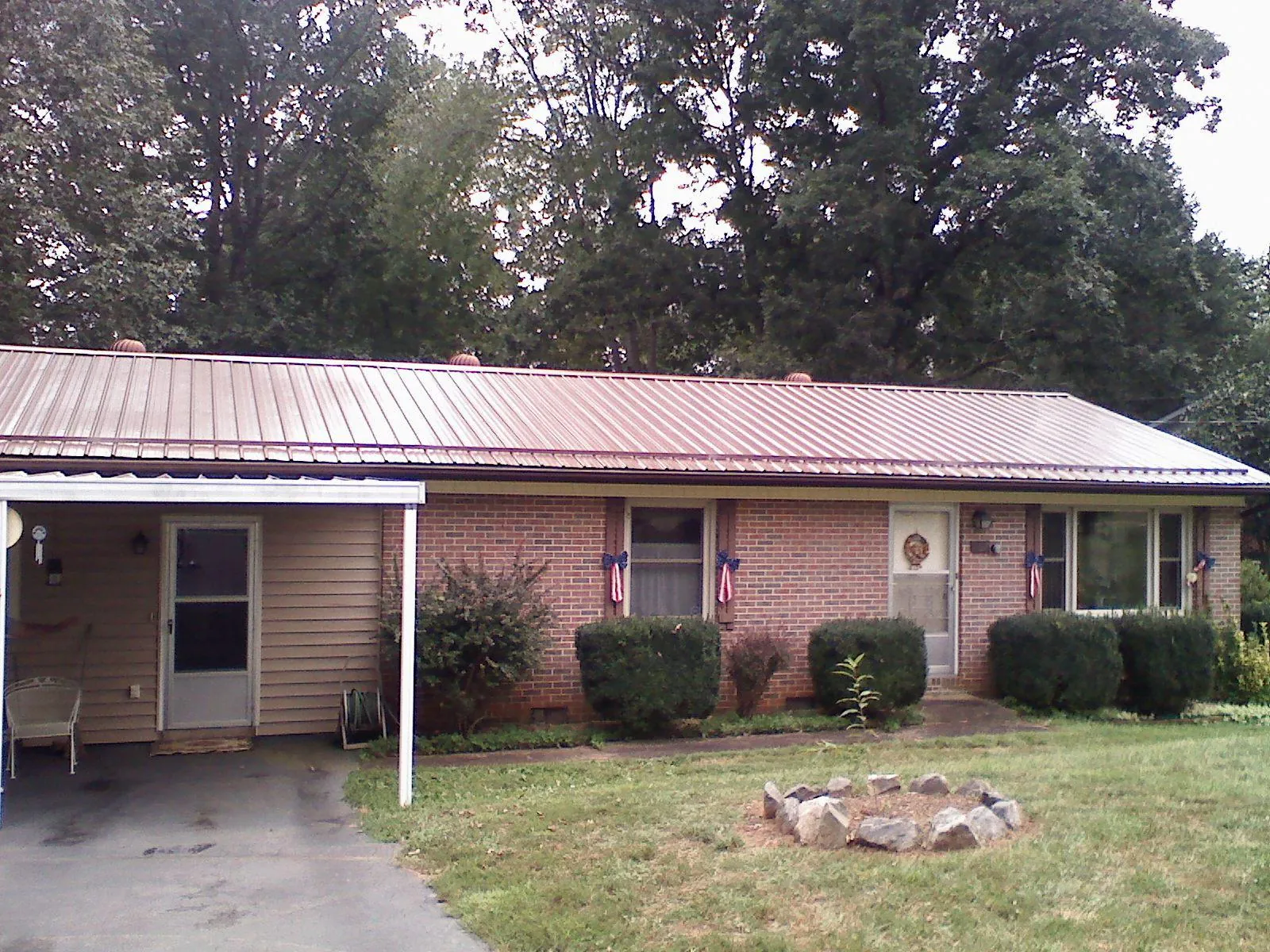 Bronze metal roof and carport on a brick ranch home — Roof Repair work by our crew in Wilmore
